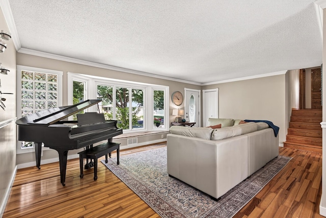 4128 Zane Ave N, Robbinsdale, MN 55422 - living area featuring a textured ceiling, healthy amount of natural light, hardwood / wood-style floors, crown molding, and stairway
