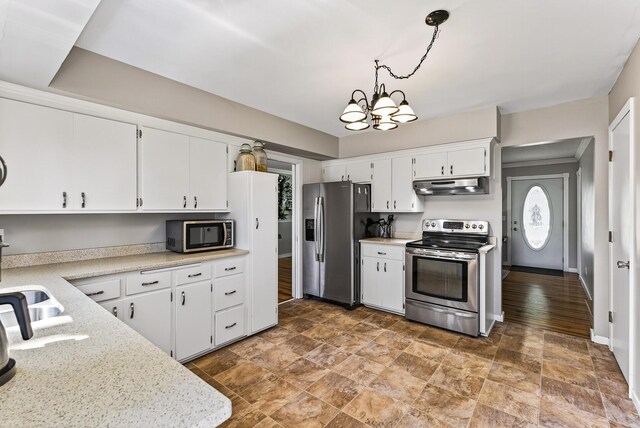 4128 Zane Ave N, Robbinsdale, MN 55422 - kitchen with appliances with stainless steel finishes, under cabinet range hood, stone finish floors, and white cabinetry