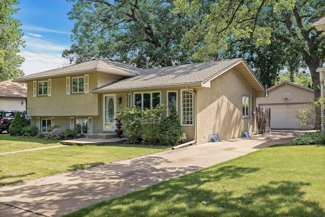 4128 Zane Ave N, Robbinsdale, MN 55422 - split level home with stucco siding, an outbuilding, a front yard, driveway, and a detached garage