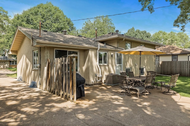 4128 Zane Ave N, Robbinsdale, MN 55422 - rear view of property with stucco siding, a patio, outdoor dining space, and a shingled roof