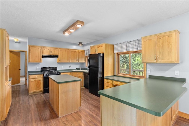 2224 75th Ave Unit M, Osceola, WI 54020 - kitchen with black appliances, a peninsula, dark wood-type flooring, a center island, and dark countertops