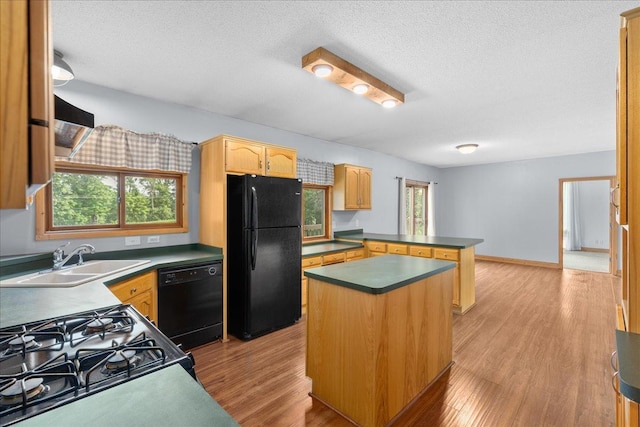 2224 75th Ave Unit M, Osceola, WI 54020 - kitchen featuring black appliances, a peninsula, light wood-style flooring, dark countertops, and a textured ceiling