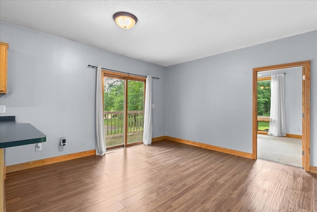 2224 75th Ave Unit M, Osceola, WI 54020 - unfurnished living room with wood finished floors, healthy amount of natural light, and a textured ceiling