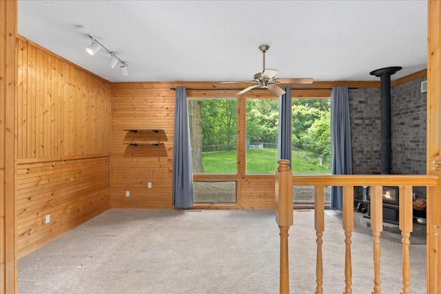 2224 75th Ave Unit M, Osceola, WI 54020 - unfurnished sunroom featuring healthy amount of natural light, a wood stove, and track lighting