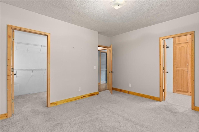 2224 75th Ave Unit M, Osceola, WI 54020 - unfurnished bedroom with carpet, a spacious closet, a textured ceiling, and a closet