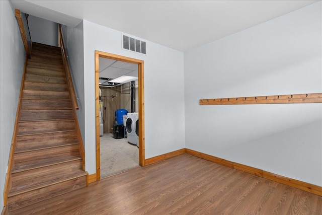 2224 75th Ave Unit M, Osceola, WI 54020 - empty room featuring independent washer and dryer, wood finished floors, and stairway