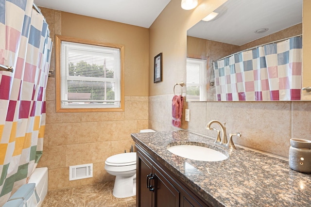 522 14th St NE, Owatonna, MN 55060 - bathroom featuring tile walls, vanity, and shower / tub combo
