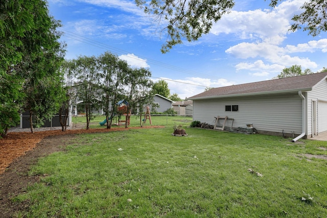 522 14th St NE, Owatonna, MN 55060 - fenced backyard with a playground, a garage, and an outdoor fire pit
