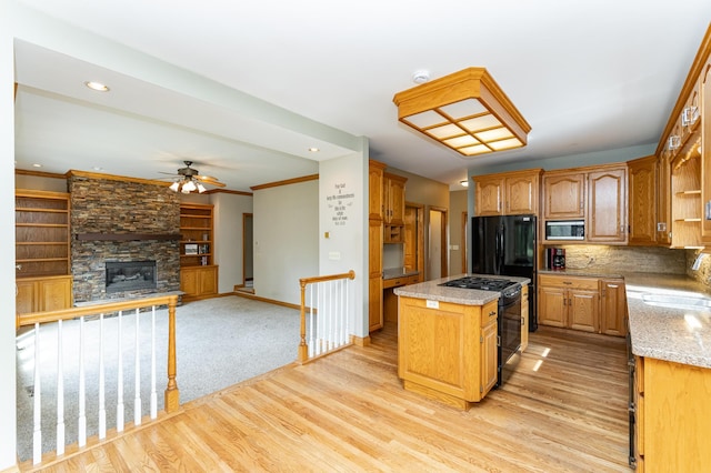 4354 48th St NE, Haverhill Twp, MN 55906 - kitchen with stainless steel microwave, black gas range, ceiling fan, a center island, and light stone countertops