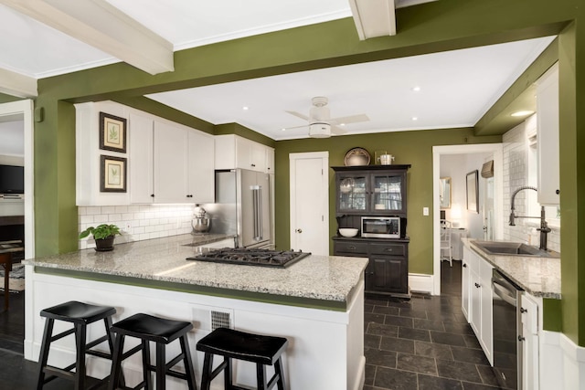1064 Lombard Ave, Saint Paul, MN 55105 - kitchen featuring appliances with stainless steel finishes, a peninsula, tasteful backsplash, white cabinetry, and ceiling fan