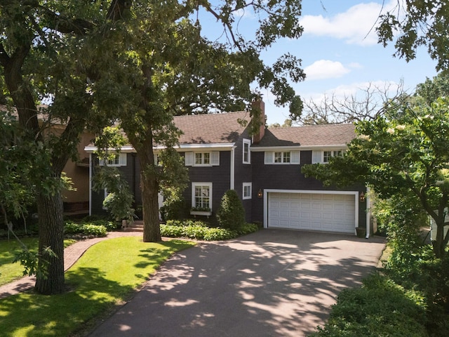 1064 Lombard Ave, Saint Paul, MN 55105 - view of front of house with driveway, a chimney, a garage, and a front yard