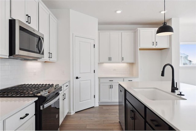 1682 Tyrone Dr, Shakopee, MN 55379 - kitchen with appliances with stainless steel finishes, white cabinetry, light wood-type flooring, light countertops, and recessed lighting