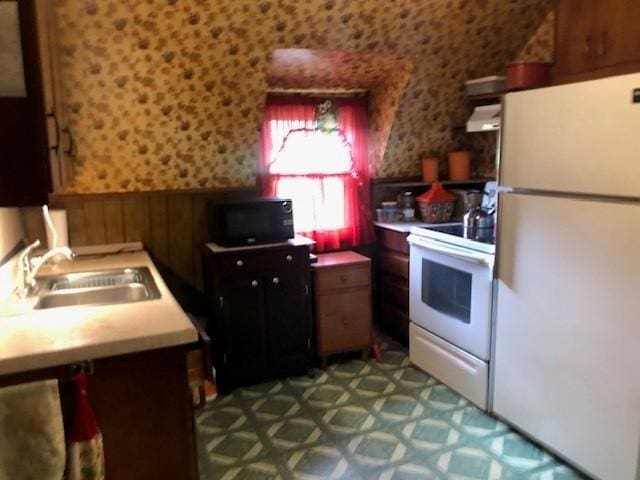 604 Elliott Ave N, Glencoe, MN 55336 - kitchen with white appliances, wainscoting, range hood, light countertops, and dark flooring