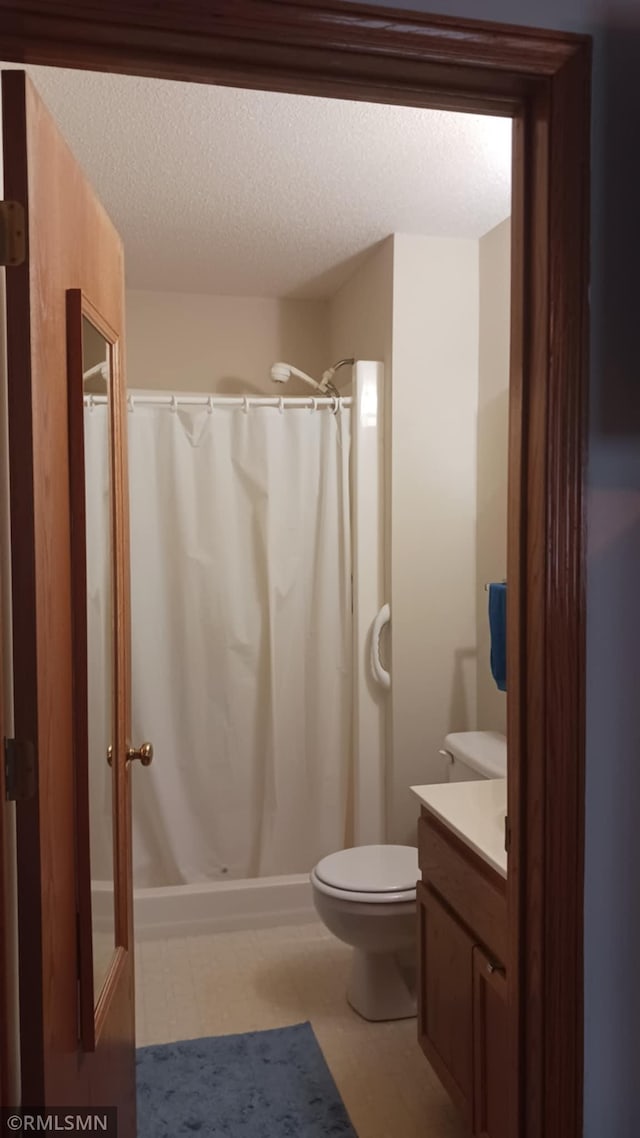 10933 57th St NE, Albertville, MN 55301 - bathroom featuring tile patterned floors, vanity, curtained shower, and a textured ceiling