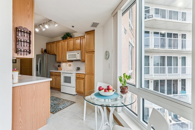 6600 Lyndale Ave S Unit 503, Richfield, MN 55423 - kitchen featuring white appliances, rail lighting, light tile patterned floors, and light countertops