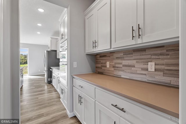 17205 61st St NE, Otsego, MN 55330 - kitchen with white cabinets, light countertops, light wood-style flooring, decorative backsplash, and recessed lighting