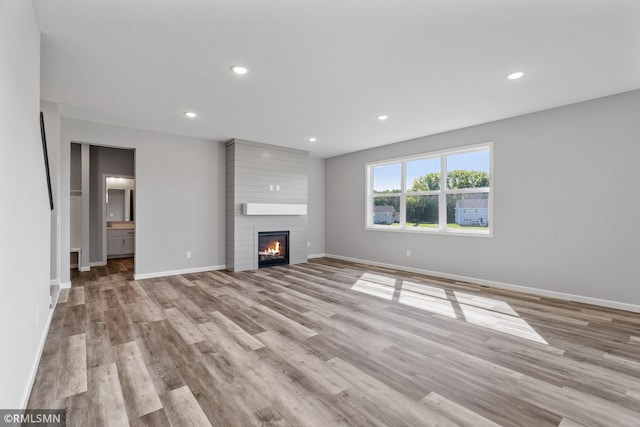 17205 61st St NE, Otsego, MN 55330 - unfurnished living room featuring light wood finished floors, a large fireplace, and recessed lighting