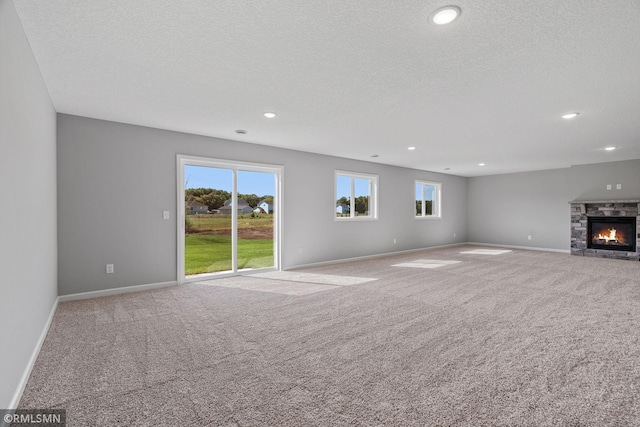 17205 61st St NE, Otsego, MN 55330 - unfurnished living room featuring carpet floors, recessed lighting, a fireplace, and a textured ceiling