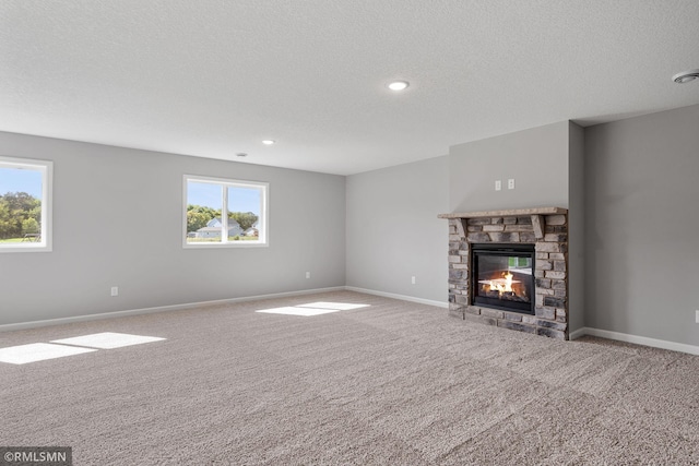 17205 61st St NE, Otsego, MN 55330 - unfurnished living room featuring carpet flooring, healthy amount of natural light, a stone fireplace, a textured ceiling, and recessed lighting