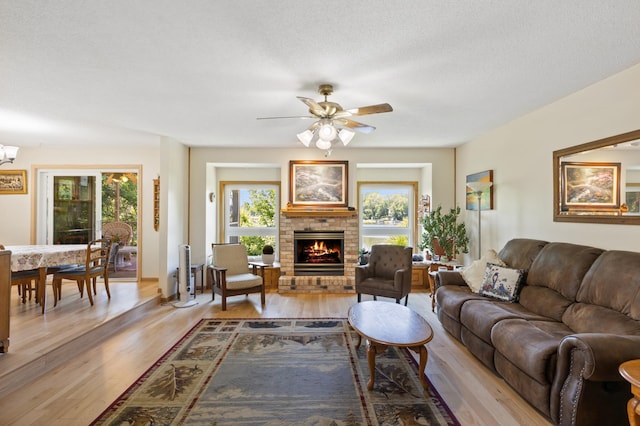 30190 Terryll St, Lindstrom, MN 55045 - living room featuring wood finished floors, a ceiling fan, and a brick fireplace