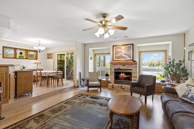 30190 Terryll St, Lindstrom, MN 55045 - living area featuring light wood-style floors, a brick fireplace, a chandelier, and ceiling fan