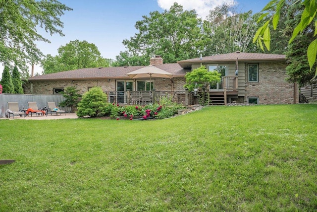 4111 Auburn Dr, Minnetonka, MN 55305 - rear view of property featuring a chimney, a deck, a yard, brick siding, and a patio