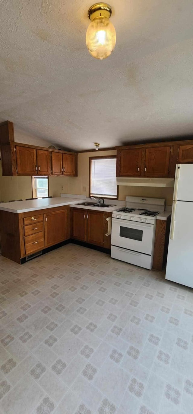 4550 Central Ave NE Unit 1011, Hilltop, MN 55421 - kitchen featuring white appliances, a textured ceiling, light countertops, and brown cabinets