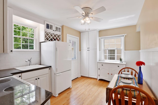 5521 Emerson Ave S, Minneapolis, MN 55419 - kitchen featuring freestanding refrigerator, white cabinetry, ceiling fan, backsplash, and light wood-style floors