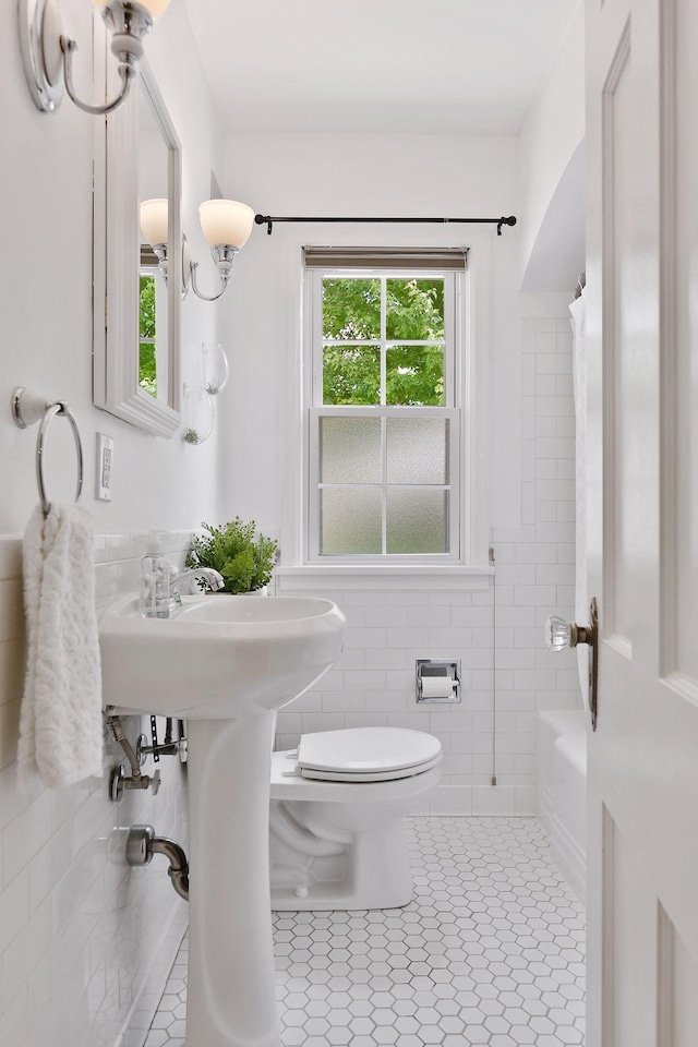 5521 Emerson Ave S, Minneapolis, MN 55419 - bathroom with tile walls, tile patterned flooring, shower / bath combo with shower curtain, and a wainscoted wall