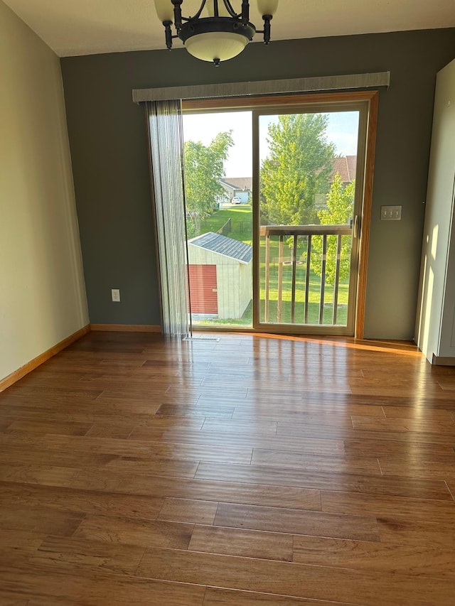 2460 Fox Hollow Ln, Owatonna, MN 55060 - empty room with plenty of natural light, wood finished floors, and a chandelier