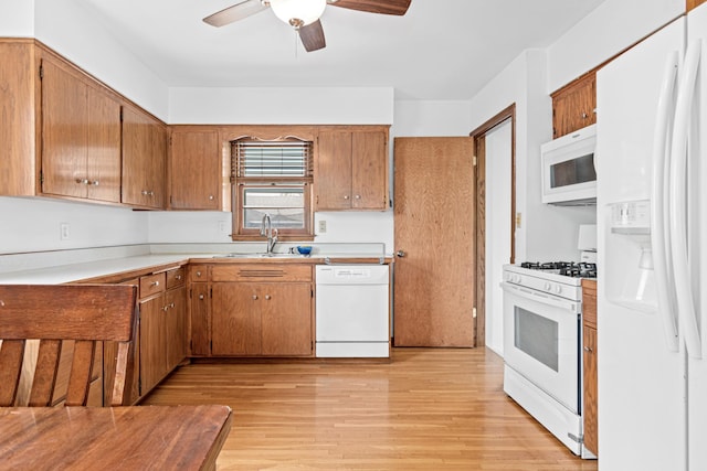 3836 Buchanan St NE, Columbia Heights, MN 55421 - kitchen featuring white appliances, ceiling fan, light wood-style flooring, brown cabinetry, and light countertops