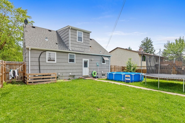 3836 Buchanan St NE, Columbia Heights, MN 55421 - rear view of property featuring a trampoline, a shingled roof, a fenced backyard, and entry steps