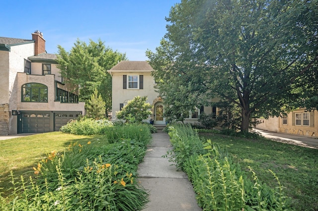 129 50th St, Minneapolis, MN 55419 - obstructed view of property featuring stucco siding, an attached garage, a front yard, and a chimney