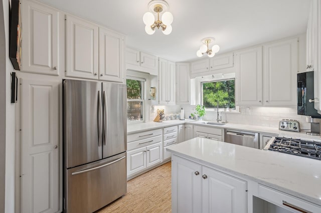 129 50th St, Minneapolis, MN 55419 - kitchen with appliances with stainless steel finishes, white cabinets, and decorative backsplash