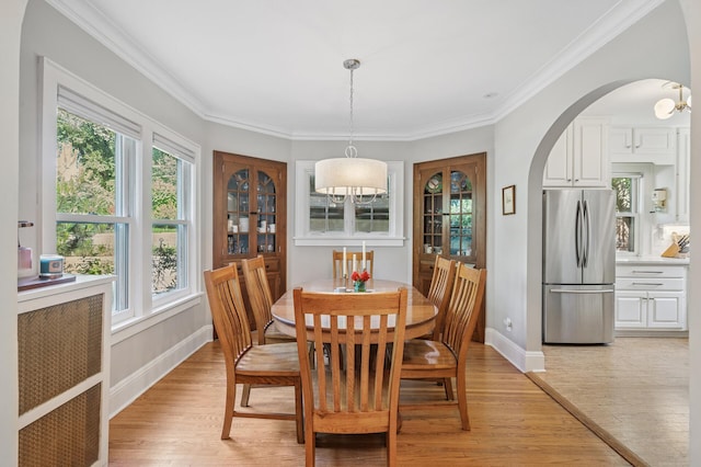 129 50th St, Minneapolis, MN 55419 - dining space with light wood-type flooring, arched walkways, ornamental molding, and a chandelier