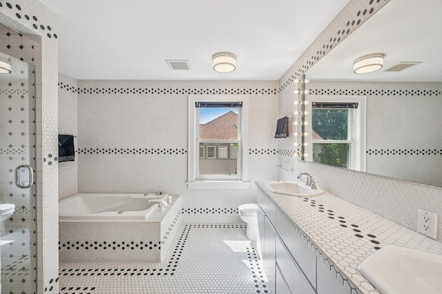 129 50th St, Minneapolis, MN 55419 - bathroom with tile walls, double vanity, a garden tub, a stall shower, and healthy amount of natural light
