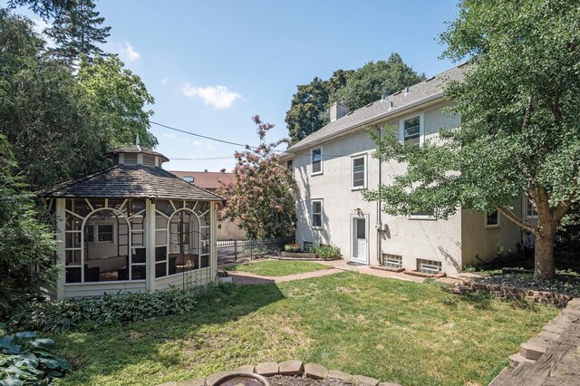 129 50th St, Minneapolis, MN 55419 - back of property with stucco siding, a gazebo, and roof with shingles