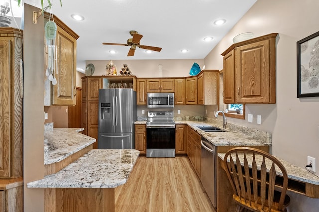 7023 State Highway 114 SW, Lake Mary Twp, MN 56308 - kitchen featuring appliances with stainless steel finishes, brown cabinetry, ceiling fan, light wood-type flooring, and light stone counters