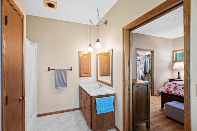 7023 State Highway 114 SW, Lake Mary Twp, MN 56308 - bathroom with vanity, a closet, ensuite bath, and marble look tile flooring