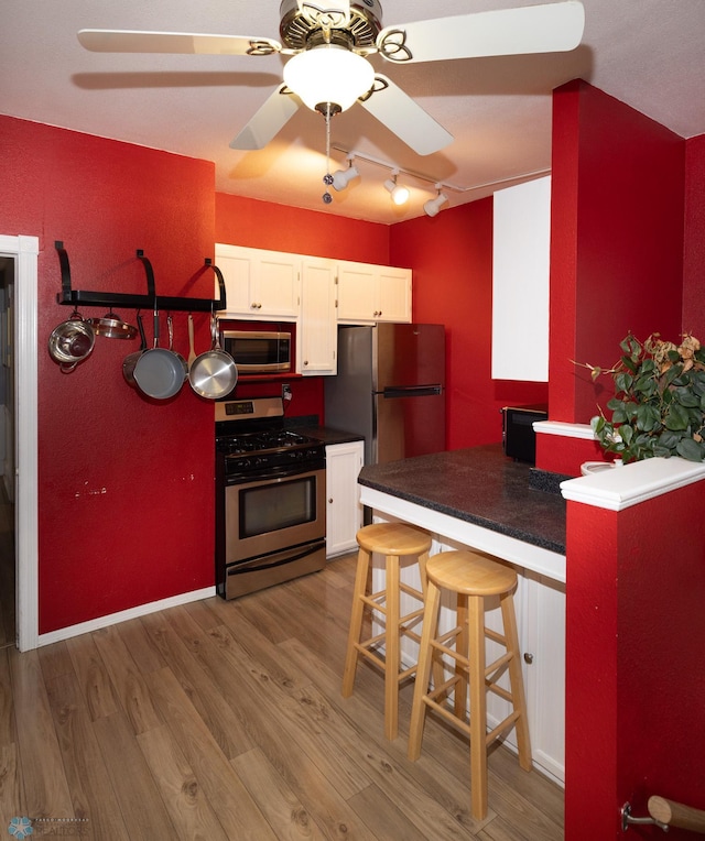 1341 3rd Ave N, Fargo, ND 58102 - kitchen featuring appliances with stainless steel finishes, white cabinetry, dark countertops, and wood finished floors