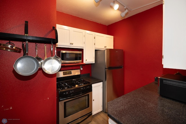 1341 3rd Ave N, Fargo, ND 58102 - kitchen featuring stainless steel appliances, dark countertops, white cabinets, wood finished floors, and rail lighting