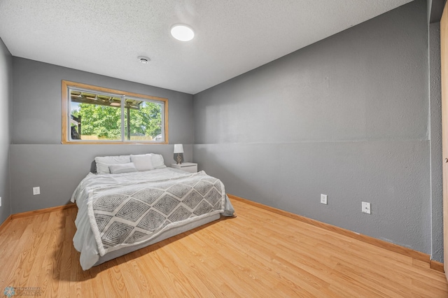1030 Oak Pl, West Fargo, ND 58078 - bedroom featuring wood finished floors and a textured ceiling