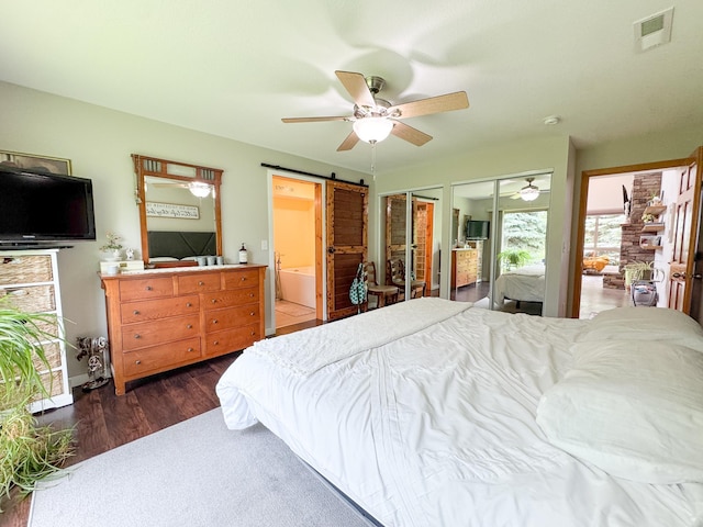 23336 County Highway 120, Fergus Falls, MN 56537 - bedroom featuring a barn door, two closets, wood finished floors, a ceiling fan, and ensuite bath