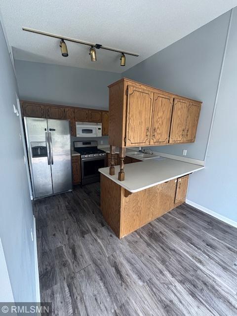 421 Dorland Rd S, Maplewood, MN 55119 - kitchen with stainless steel appliances, dark wood-style floors, a peninsula, brown cabinetry, and light countertops