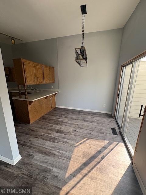421 Dorland Rd S, Maplewood, MN 55119 - kitchen with brown cabinetry, a peninsula, dark wood-style floors, and hanging light fixtures