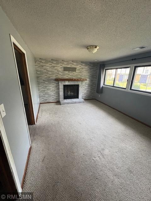 421 Dorland Rd S, Maplewood, MN 55119 - unfurnished living room featuring carpet floors, a brick fireplace, and a textured ceiling