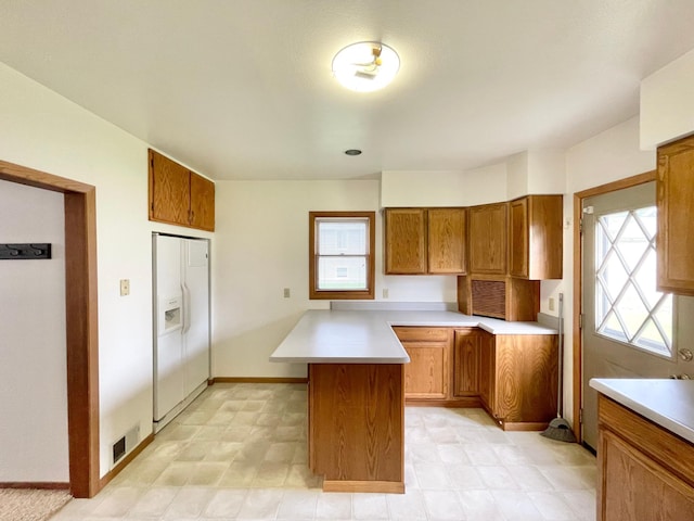 212 Sanborn St, Springfield, MN 56087 - kitchen featuring brown cabinetry, healthy amount of natural light, light countertops, and white fridge with ice dispenser