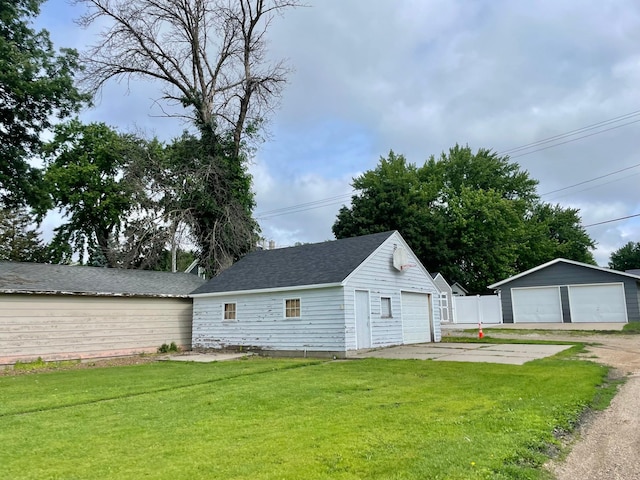 212 Sanborn St, Springfield, MN 56087 - view of side of property with a garage, an outdoor structure, a lawn, and a shingled roof