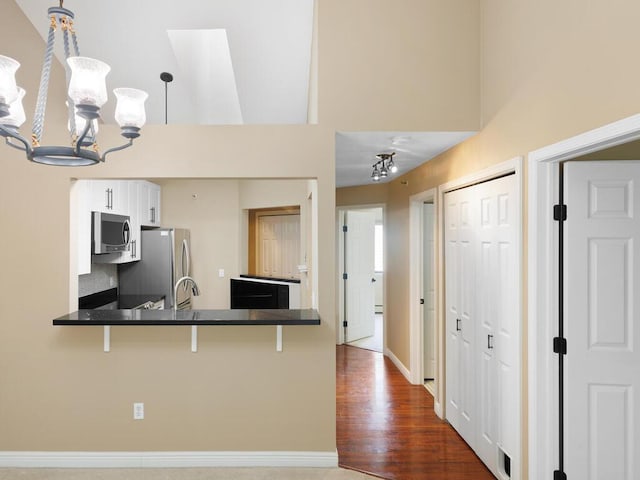 7605 Edinborough Way Unit 6314, Edina, MN 55435 - kitchen featuring stainless steel appliances, a chandelier, a breakfast bar, a high ceiling, and white cabinetry