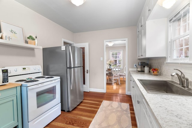 1921 James Ave, Saint Paul, MN 55105 - kitchen featuring white electric range oven, light wood-style flooring, freestanding refrigerator, and plenty of natural light